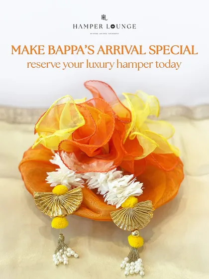 Make Bappa's arrival special with this luxury hamper. Draped in vibrant orange organza and adorned with gota patti tassels, it’s a gift that blends devotion with a touch of opulence.