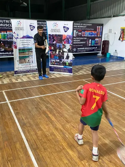 A young boy, wearing a Ronaldo jersey, gets ready to learn from a senior coach, showing that inspiration comes from all sports.