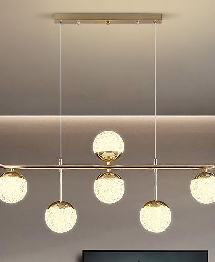 A linear pendant with six textured crystal globes. This light provides ample illumination and a touch of glamour for a dining table or island.