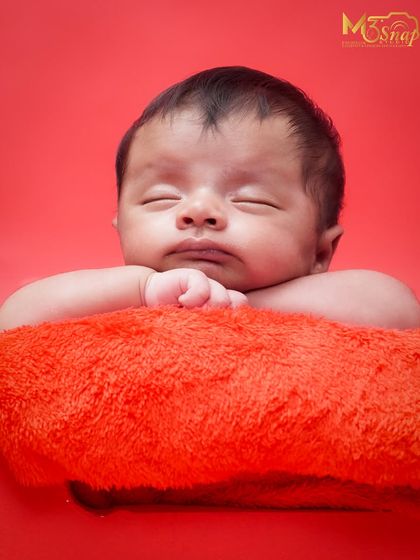 Simple, classic, and all about your baby. This portrait on a bold red background makes the baby's peaceful expression the main focus. I love how serene this little one looks.