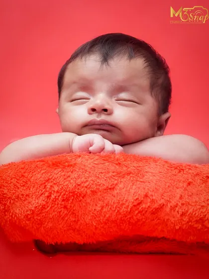 Simple, classic, and all about your baby. This portrait on a bold red background makes the baby's peaceful expression the main focus. I love how serene this little one looks.