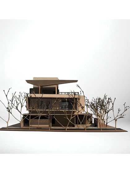 The physical model of the Akiri Residence, showcasing its complex form with overlapping roofs and cantilevered volumes. The model is meticulously crafted to represent our design intent, complete with miniature trees to simulate the landscape.