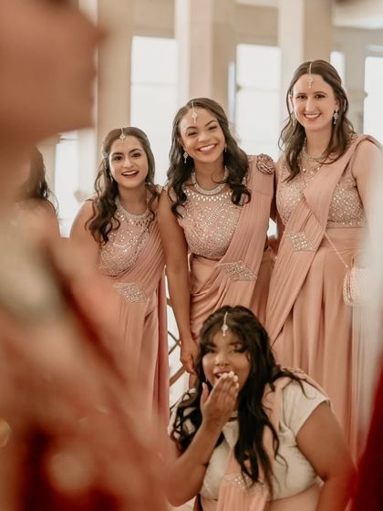 A fun, candid moment of the bridesmaids admiring the bride, captured from her point of view.
