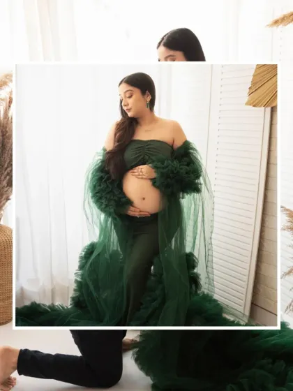 A beautiful close-up of an expecting mother in a gorgeous emerald green gown. This shot focuses on her serene expression as she cradles her baby bump.