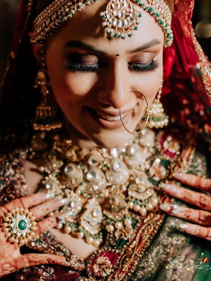 A close-up of the bride admiring her intricate jewelry and henna, a moment of quiet appreciation for her bridal details.
