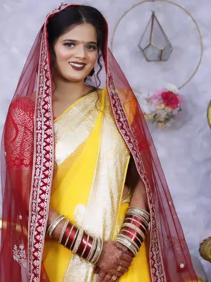 The bride with her dupatta veiled over her head, a classic pose for a North Indian wedding.