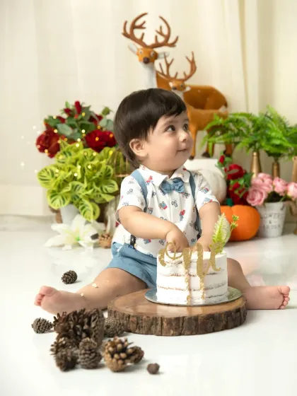 A moment of curiosity with the birthday cake. The soft lighting and festive props create a magical atmosphere for this little one's celebration.
