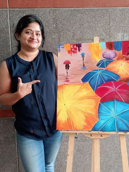 Dr. Pooja is all smiles with her colorful painting of umbrellas in the rain. This cheerful piece is a great example of how art can be fun and uplifting.