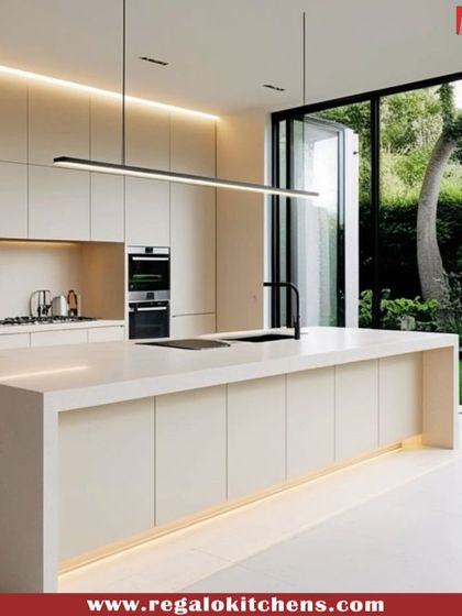 A stunning island kitchen with a view. This design features light-colored cabinetry, a large island, and floor-to-ceiling windows, blending the interior with the outdoors.