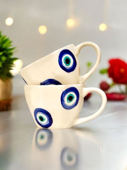 A set of beautiful ceramic cups, each hand-painted with the protective evil eye motif. They are perfect for serving drinks during festive gatherings or as a unique gift that blends utility with tradition.