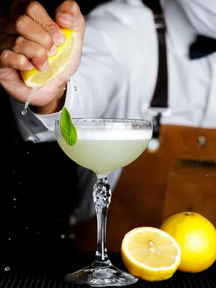A great cocktail is an experience, and the photo should be too. Here, I captured the exact moment a fresh lemon is squeezed into a gin basil smash, highlighting the craft and freshness that goes into every drink.