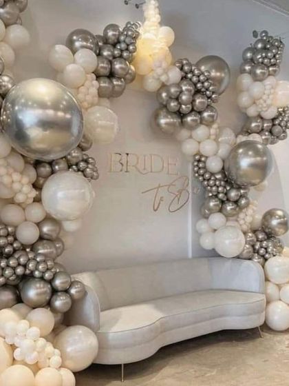 A "Bride to Be" setup in elegant monochrome. This beautiful balloon arch in shades of white, cream, and chrome silver creates a sophisticated and stylish backdrop for a bridal shower.