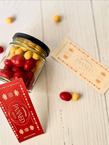 A jar of our colorful cranberry and butterscotch panned nuts, a vibrant and tasty part of our mini Rakhi hampers.