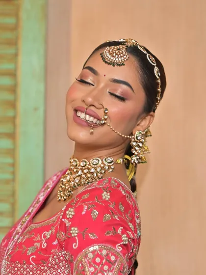 The pure happiness of a bride. This close-up shot beautifully captures her smile and the intricate details of her kundan choker, matha patti, and nath, essential pieces for a classic bridal look.
