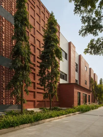The facade of the Campus Biovet office block showcases our philosophy of using honest, regional materials. A double-walled brick cladding, inspired by the local brick factories of Malur, creates a textured, linear pattern that is softened by the surrounding landscape and tall trees we carefully preserved during construction.