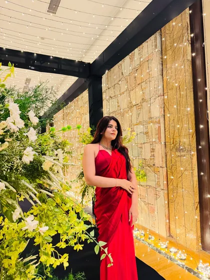 A stunning look in a simple yet elegant red satin saree, perfect for a cocktail party or reception. The fairy lights in the background add a magical touch.
