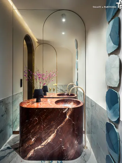 A serene and dramatic bathroom in our Palais Royale showflat. A custom-crafted vanity in rich, deep-hued marble commands the space, offering texture and contrast against the soft limewash tones and Tempest White marble seen throughout the rest of the home.