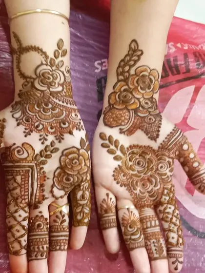 This is a great example of a simple yet elegant party mehendi. The design focuses on a bold rose pattern with leafy vines, perfect for guests at any event.