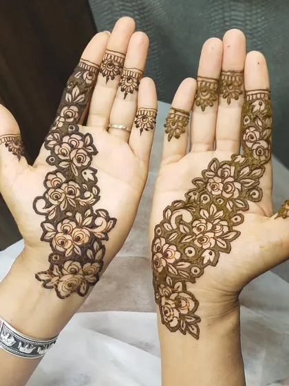 This floral Arabic mehendi is a classic choice for guests. The design flows beautifully along one side of the hand, making it look elegant without being too heavy, so you can get back to the party quickly.