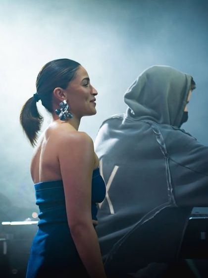 A candid moment between Alia Bhatt and Alan Walker on stage, enjoying the incredible atmosphere.