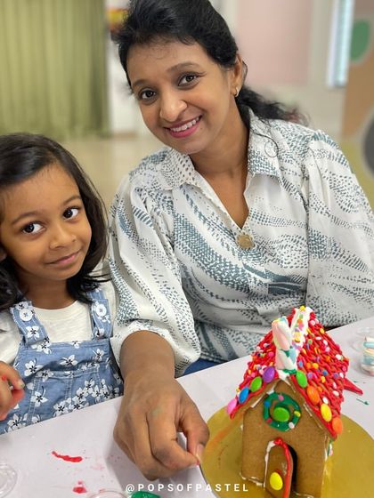 All smiles from this mother and daughter after finishing their colorful and whimsical gingerbread house.