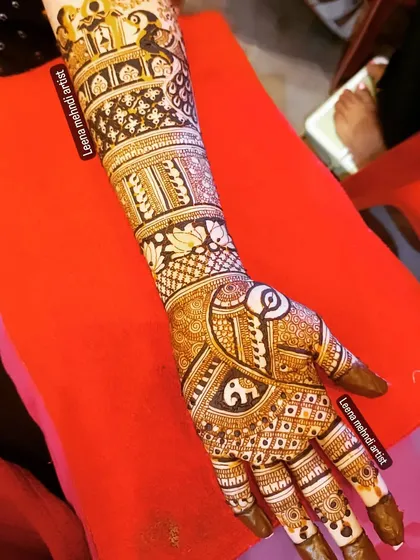 A full-arm bridal design packed with detail. This pattern includes elephants, peacocks, and architectural elements, telling a story from the palm to the elbow.
