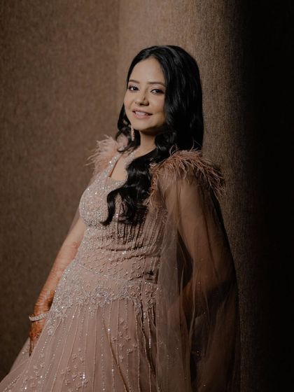 A beautifully lit portrait of the Roka bride. The soft focus highlights her glowing skin and the delicate details of her feather-trimmed gown.