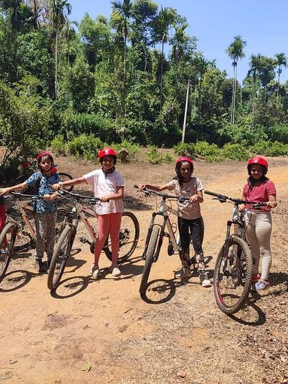 A group of girls with their mountain bikes on a dirt path, ready for their cycling adventure.