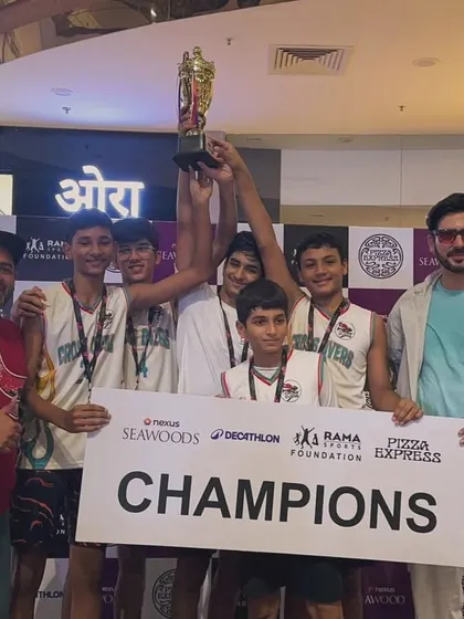 The U-14 boys team hoisting their championship trophy high. This victory at the Seawoods Nexus mall tournament was a result of their collective effort and strategic play.