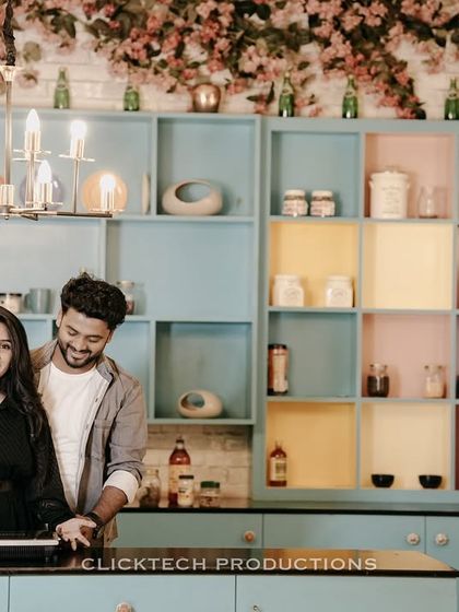 A sweet pre-wedding photo of a couple in a colorful, retro-style kitchen set.