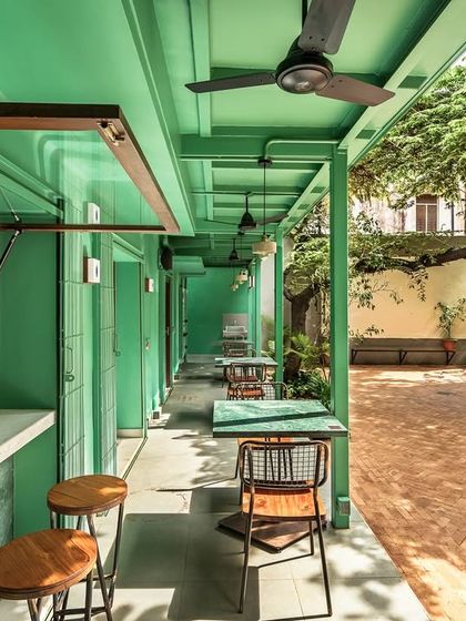 A service window opens directly onto the courtyard, integrating the coffee-making process with the outdoor seating area. This design choice fosters a sense of connection and transparency, making the preparation of food and drink part of the overall community experience.