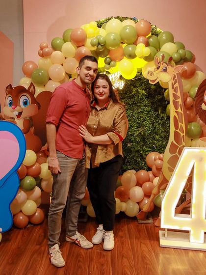 A couple poses in front of a slightly different jungle theme, showing our ability to customize the decor to our client's preferences.