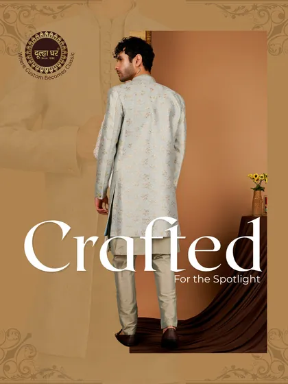 Crafted for the spotlight. A model turns to show the back of a light blue Indo-Western jacket, highlighting its long silhouette and elegant drape.
