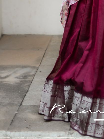 The silver border on the brick maroon silk skirt adds a touch of subtle shimmer and traditional charm.