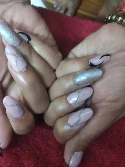 This set of almond-shaped acrylic extensions features a soft pink base with chrome powder, silver glitter lines, and black accents for a modern and edgy look.