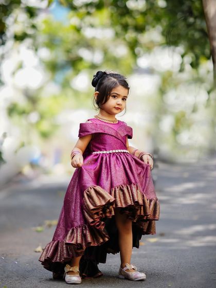 A beautiful outdoor portrait of a little girl celebrating her third birthday in a gorgeous high-low purple dress.