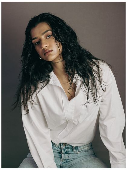 This shot provides a clear view of the full "wet look" hairstyle. The model's direct gaze adds confidence, while the styling remains the hero. It's a clean, effective shot for a hair stylist's portfolio or a product campaign.