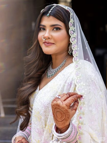 A close up on her beautiful face and henna. The makeup is minimal yet polished, letting her natural beauty shine.