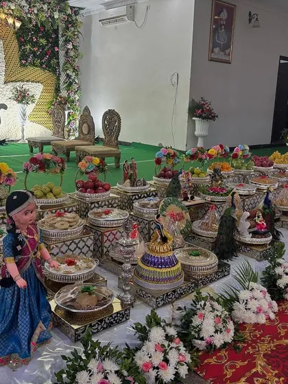 A stage with a large white floral lotus backdrop and a green floor.