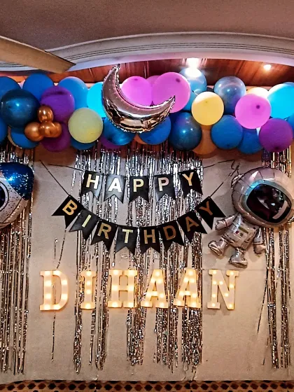 A close-up of the home-based space theme, showing the marquee letters 'DIHAAN' and the arrangement of balloons and props around the main backdrop.
