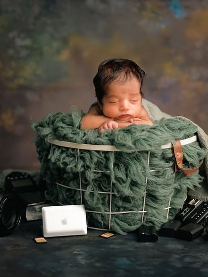 A playful nod to my own profession with this 'Baby Director' theme. The newborn sleeps soundly in a basket surrounded by miniature cameras, lenses, and even a tiny laptop, as if they're the boss of the studio.