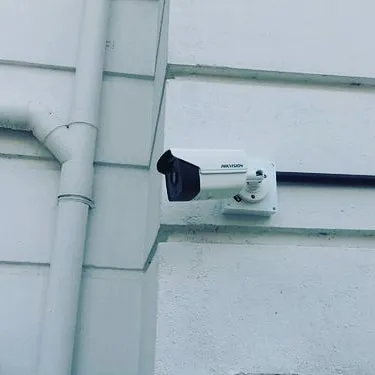 Here is a clean installation of a Hikvision outdoor bullet camera on a building's exterior. I make sure the mounting is secure and the wiring is discreet to protect your property effectively while maintaining its appearance.