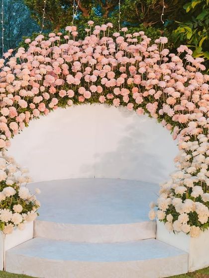 The varmala stage is pure magic. This beautiful floral arch of pink and white chrysanthemums creates the perfect backdrop for one of the most unforgettable wedding moments.