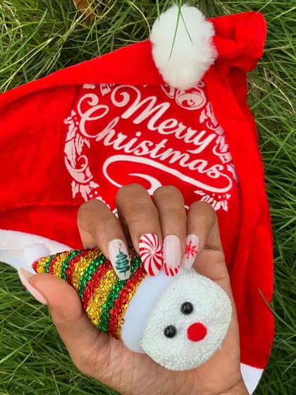 Another look at the playful Christmas nail art set, held next to a cute snowman ornament to really get into the holiday spirit.