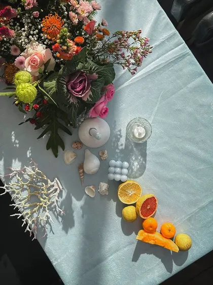A tablescape detail combining florals, fruits, and seashells, perfectly capturing a chic, coastal, and organic vibe.