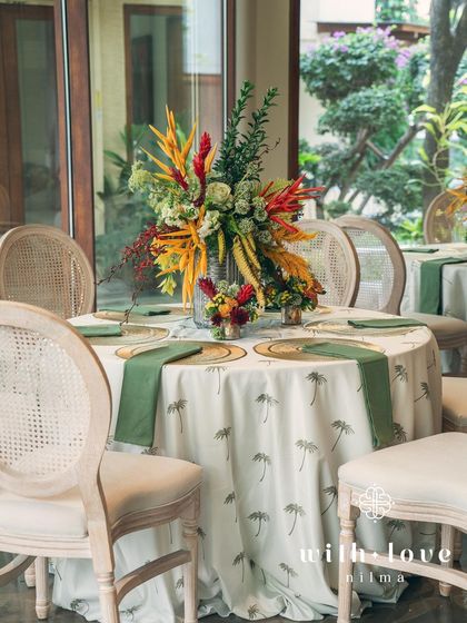 An elegant tablescape from the 'Garden of Gaia' baby shower, with a lush floral centerpiece and custom linens.
