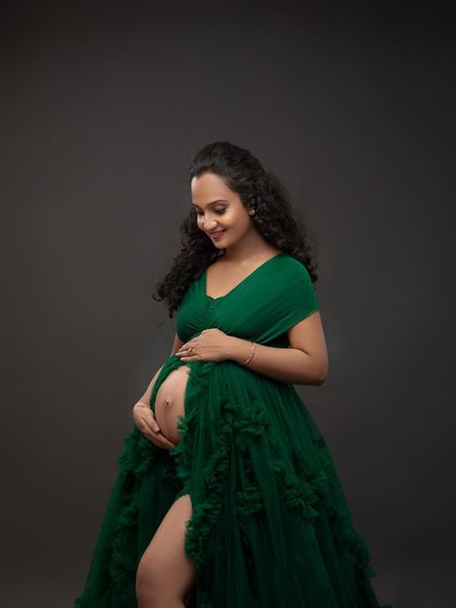 A quiet moment of connection, cradling the baby bump in the vibrant green gown. This pose is simple, timeless, and full of emotion.