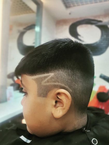 This "Z" hair tattoo is a popular choice for kids. It adds a fun, graphic element to a standard fade haircut.