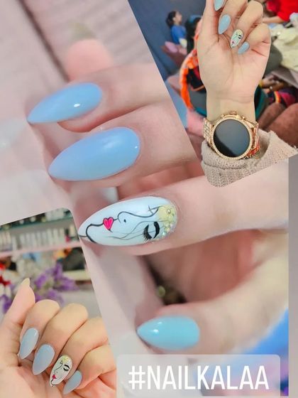 A chic and artistic set featuring solid baby blue nails with a hand-painted abstract face design on the accent nail.