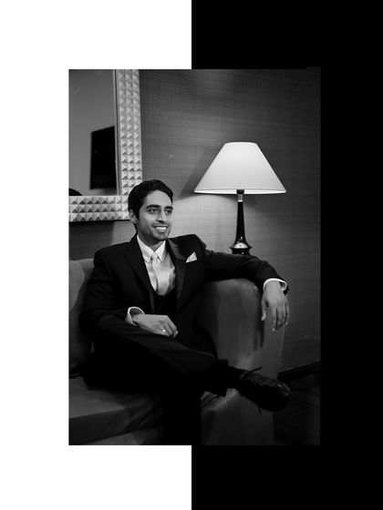 A relaxed black and white portrait of the groom, smiling candidly. This shot shows a more personal and approachable side, balancing the formal portraits.